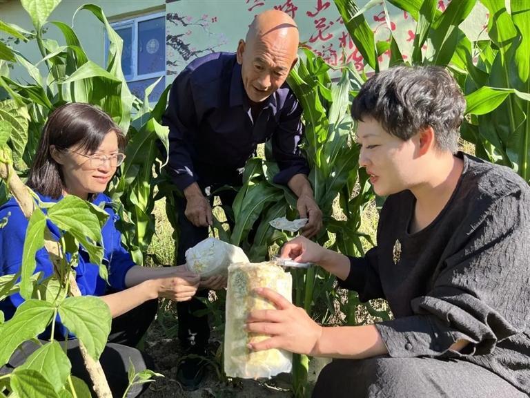 村民和驻村队员一起察看菌种生长情况