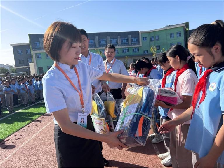 昌吉国民村镇银行吉木萨尔支行工作人员向学生发放“爱心包”