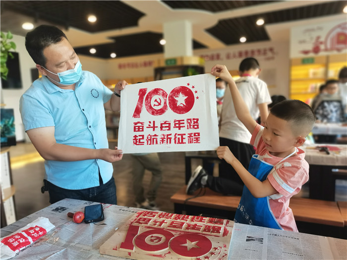 在城市书屋参加“书香馥郁·爱润心田”活动的家长和孩子一起展示木刻版画.jpg