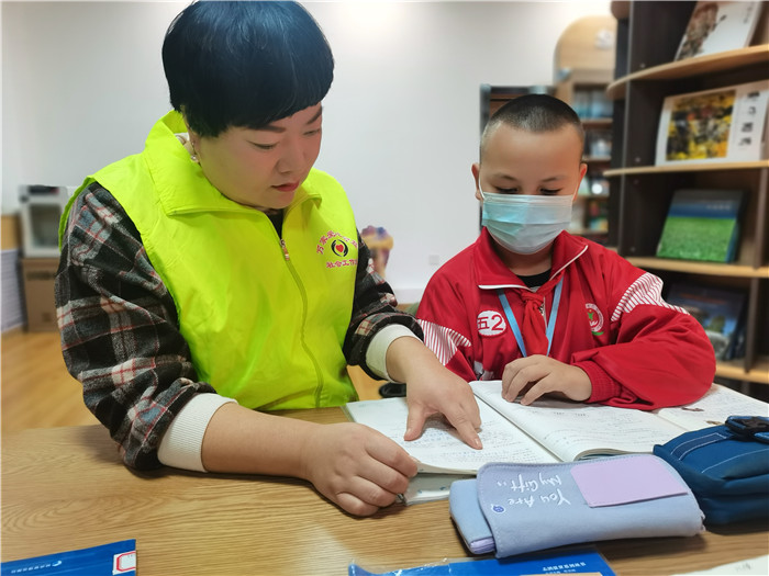 奇台县万家社会工作站在城市书屋“六点半”课堂志上为辖区学习讲解家庭作业.jpg